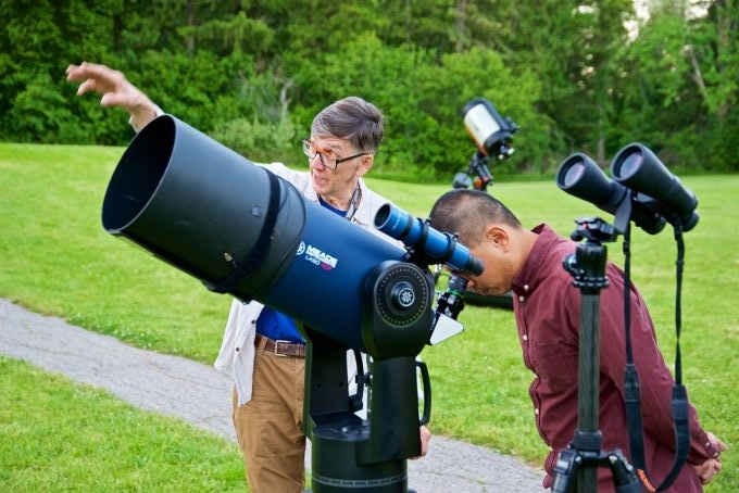volunteer sharing a view through a telescope